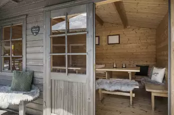 Einblick in die Holzhütte mit Sitzbänken