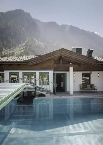 Außenansicht Pool mit Bergkulisse und Rezeption im Hintergrund
