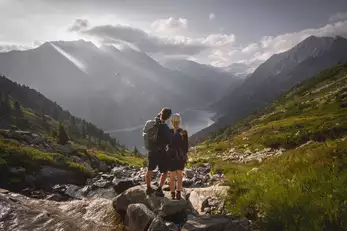 Zwei Wanderer schauen ins Tal auf den Speichersee
