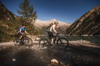 zwei Personen sind am Radfahren durch einen See