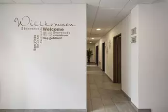 Eingang Sanitärbereich mit großer weißer Wand mit Schriftzug 