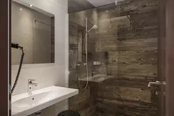 Sanitärraum mit großem Waschbecken, Föhn und Dusche 