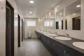 Sanitärraum mit vielen Waschbecken und WCs
